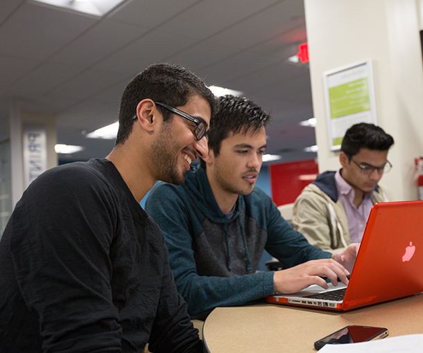 an image of students collaborating on a laptop in the learning commons 